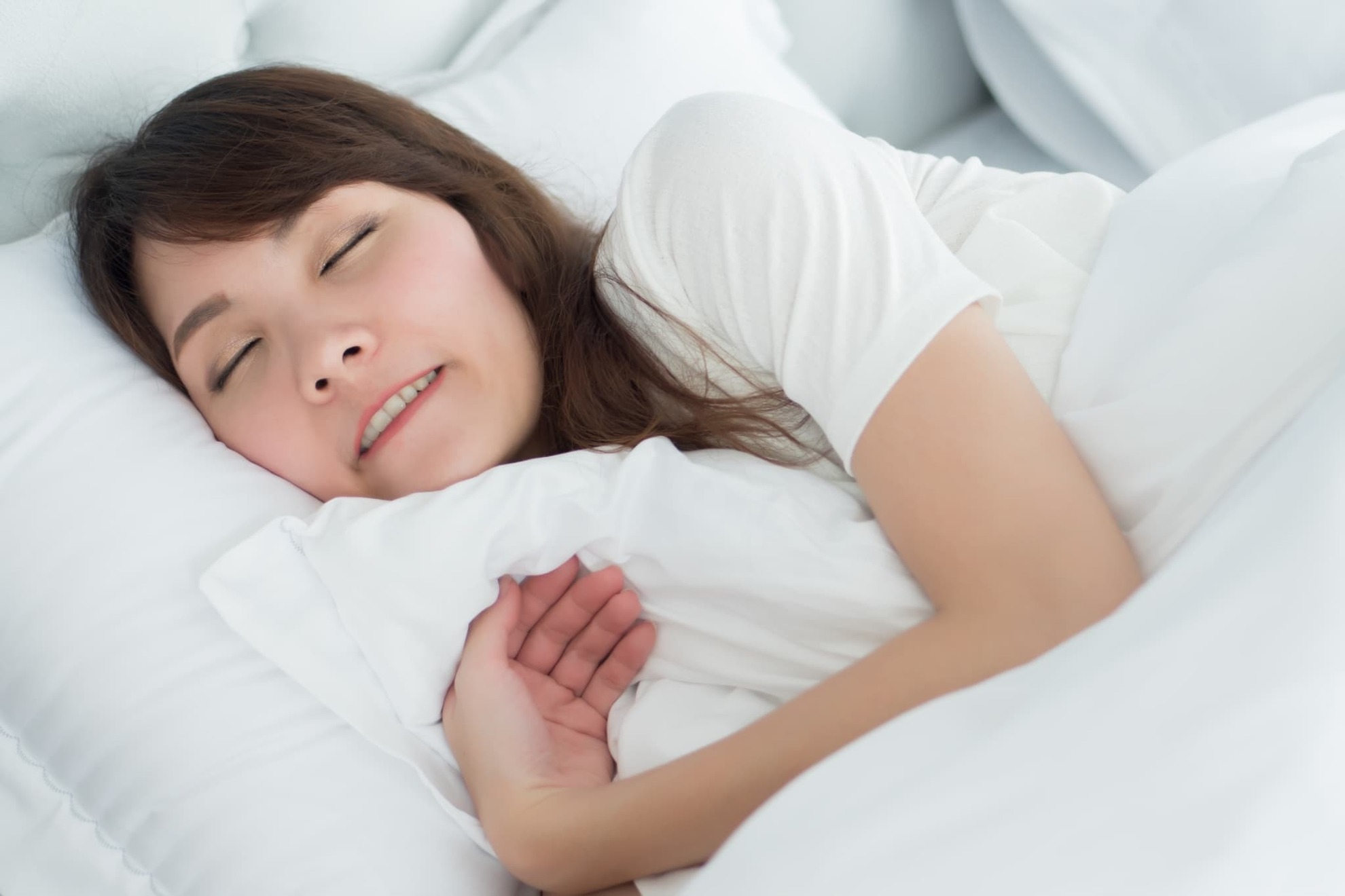 就寝中に歯ぎしりをする女性