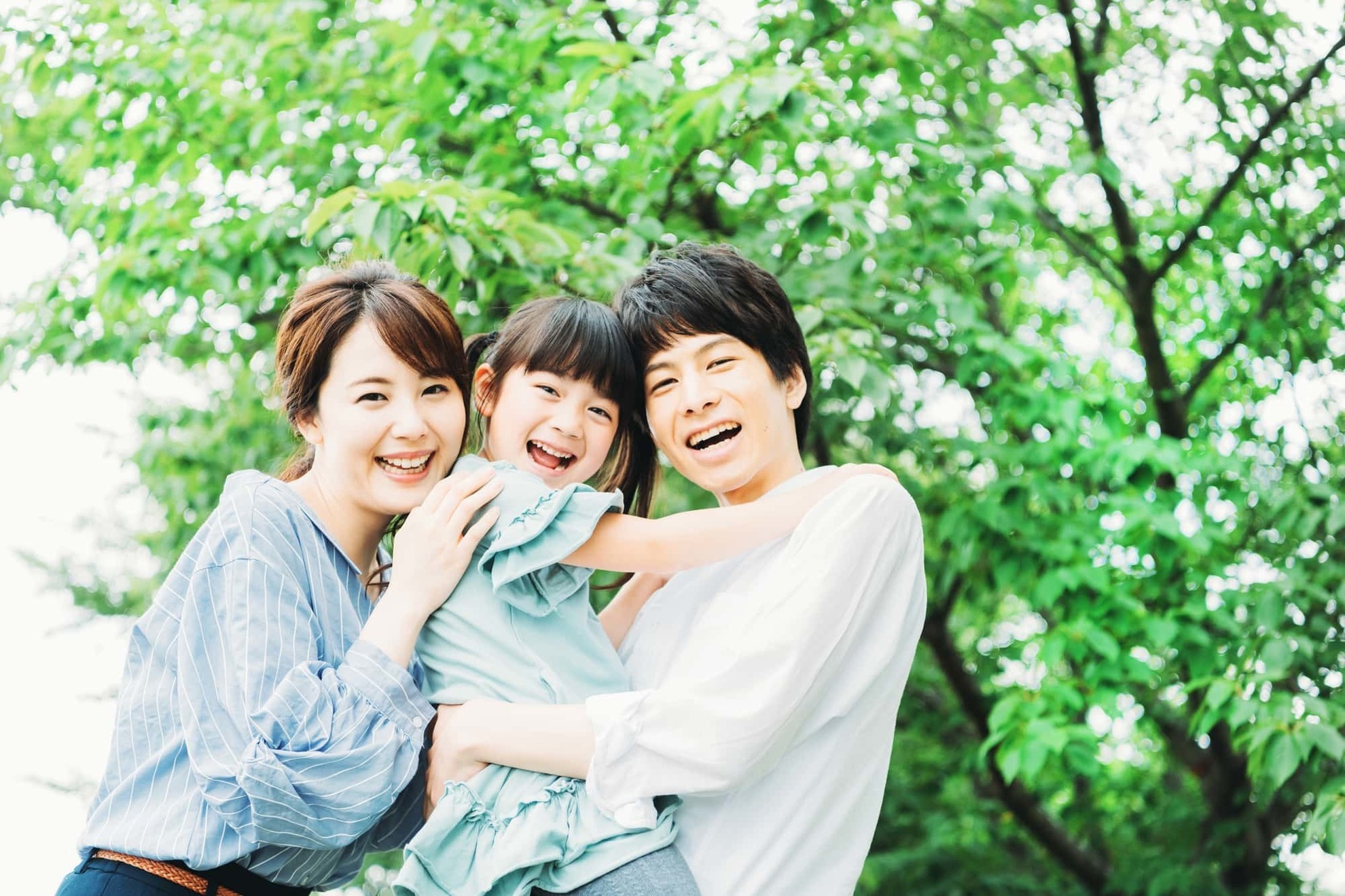 インビザライン・ファーストで綺麗な歯並びになった子どもを抱いた家族