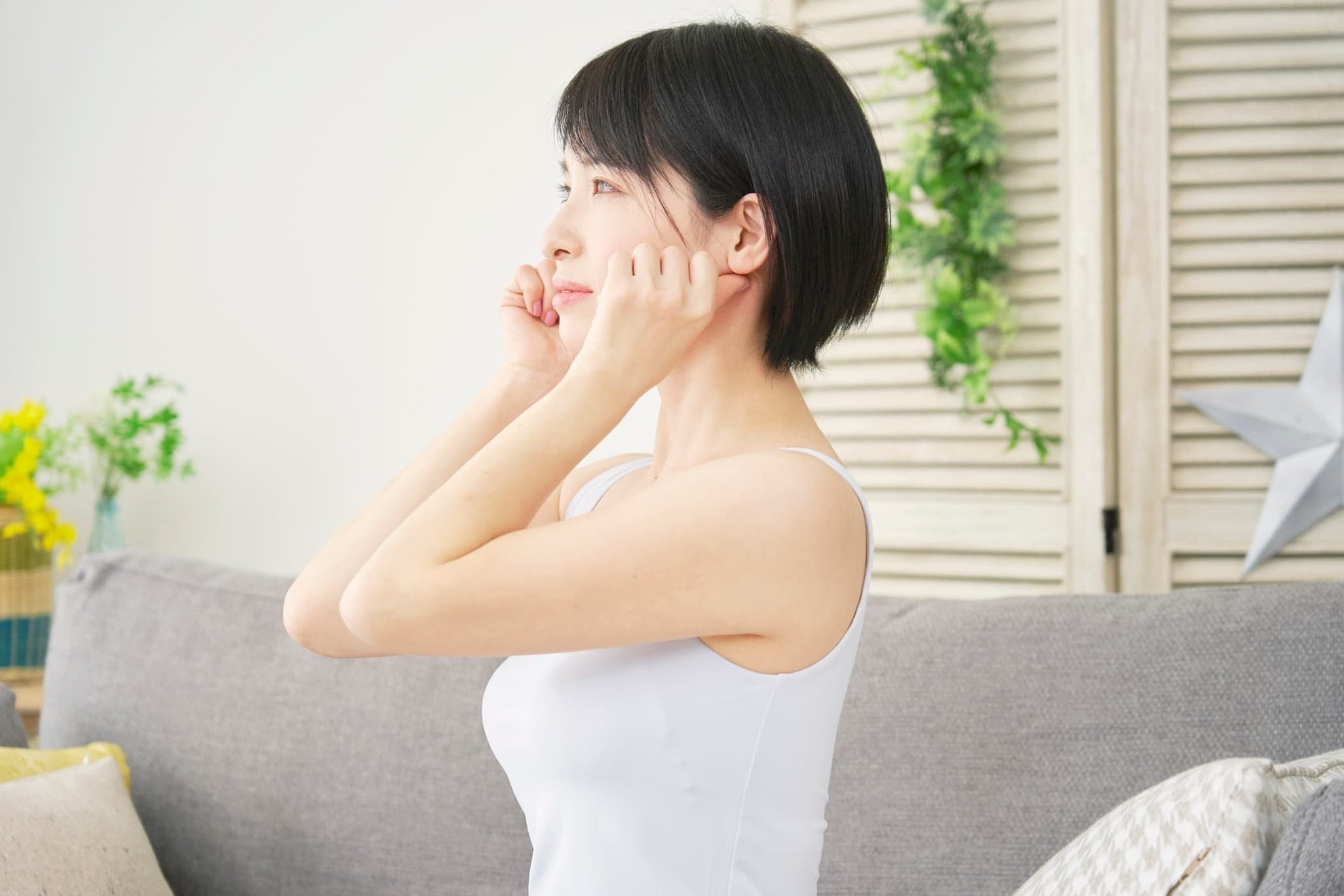 歯ぎしりを改善するために口周りのマッサージをする女性