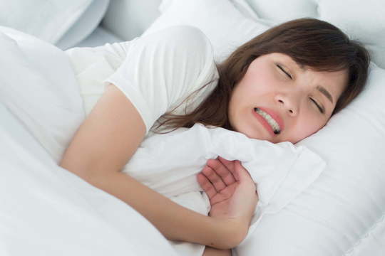 歯ぎしりをしながら眠っている女性