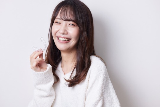 インビザラインを持った笑顔の女性