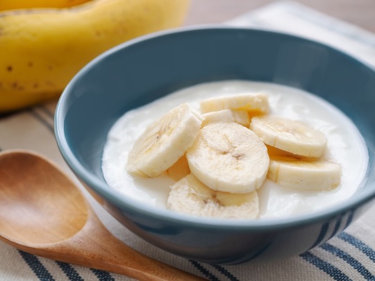 ヨーグルトにバナナのうす切りをのせたイメージ