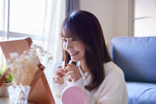 鏡を見ながらマウスピースを装着しようとしている女性