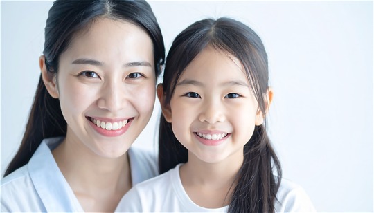 小児矯正した綺麗な歯並びに満足して微笑む親子