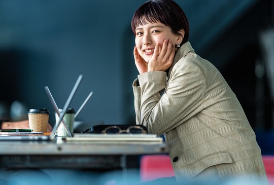 カフェで頬杖をつく女性