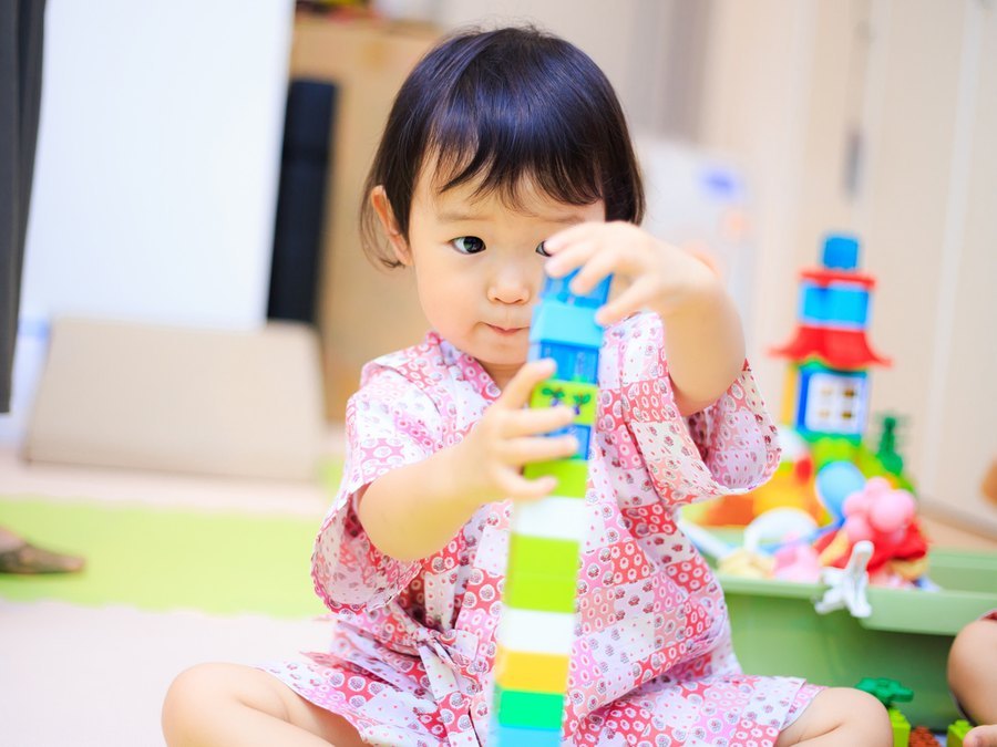 キッズルームでブロックを積んで遊ぶ女の子