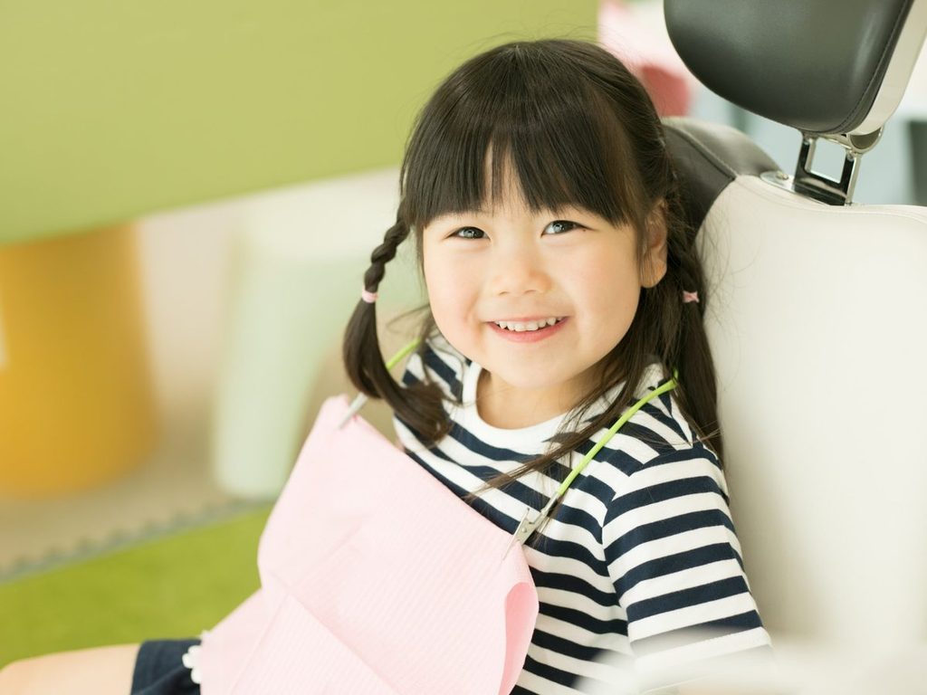 診療台で笑顔を見せる女の子